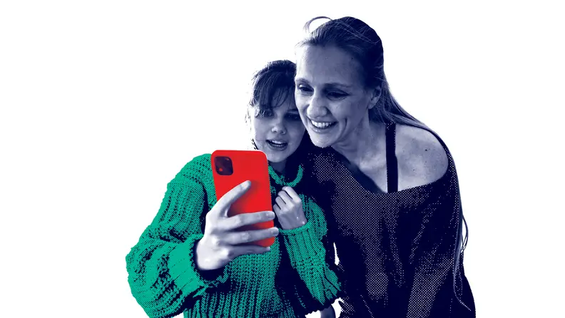 Two people smile while looking at a red smartphone together, with stylized color effects.