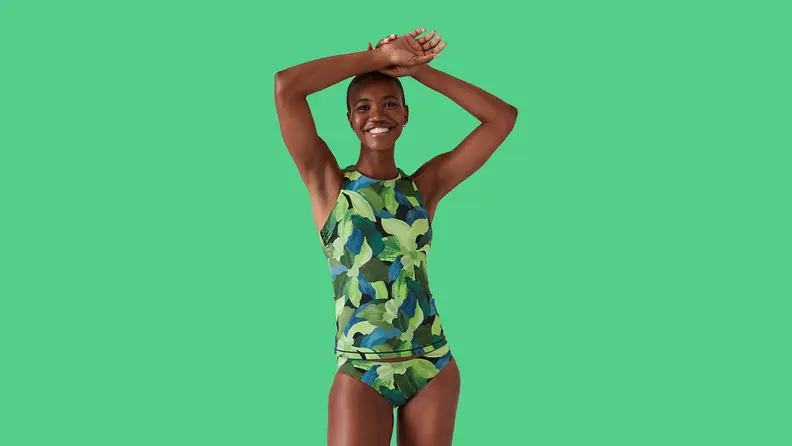 black woman wearing leaf print bikini on green background