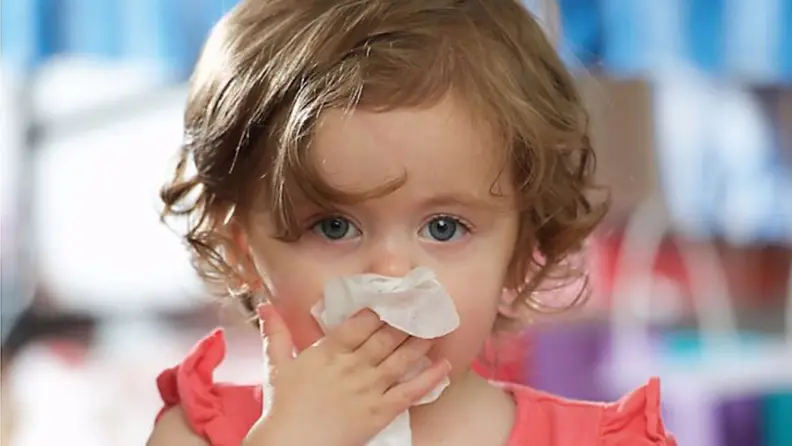 Little girl wiping her nose with a Boogie Wipe