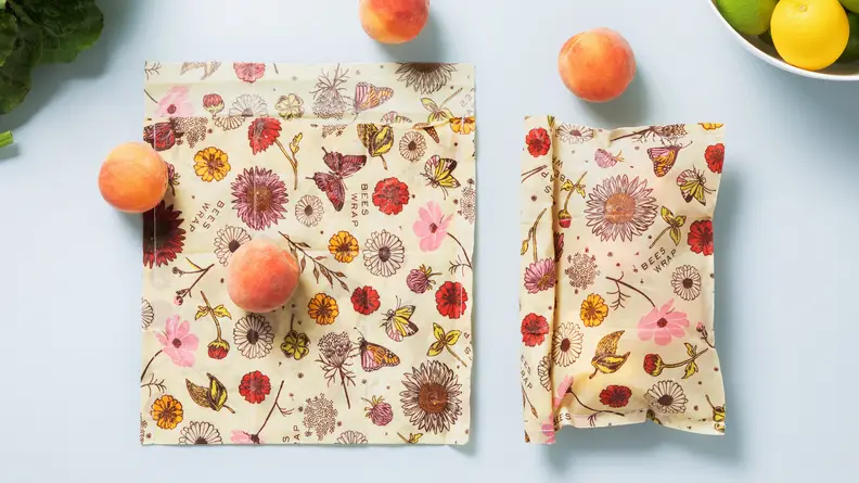 A handful of apricots roll out of a Bee's Wrap produce bag.