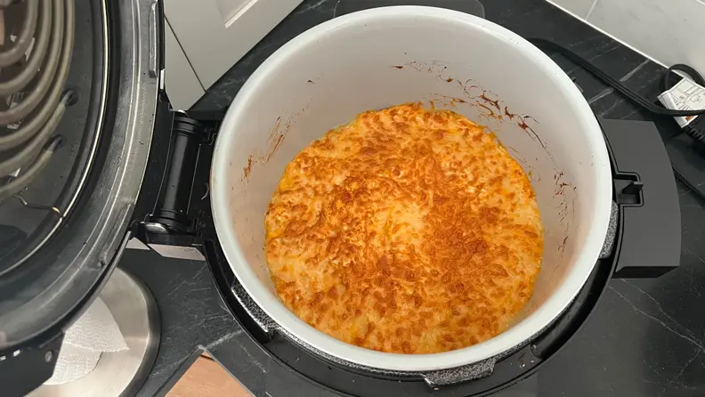 An open Ninja Foodi revealing a batch of crispy buffalo chicken dip