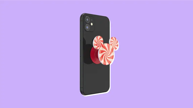 A peppermint color PopSocket in the shape of Mickey ears on an iPhone.