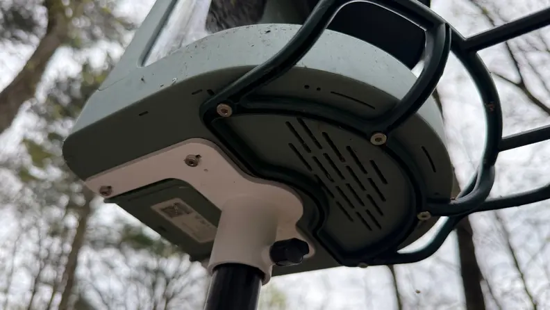 Pole mount and under-side of Kiwibit Bird Feeder 2 shown outdoors.
