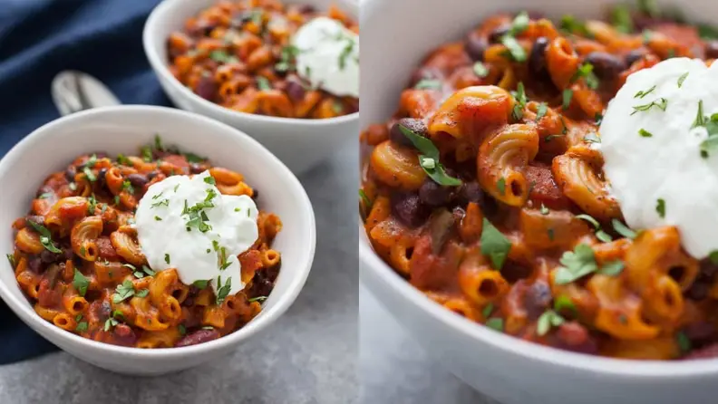 Two side-by-side shots of vegetarian chili macaroni in two white bowls, topped with sour cream and fresh cilantro.