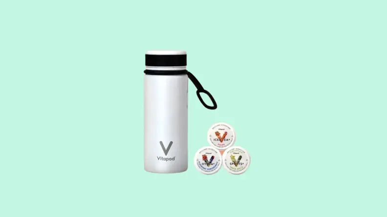 Insulated white water bottle next to assorted drink machine pods.