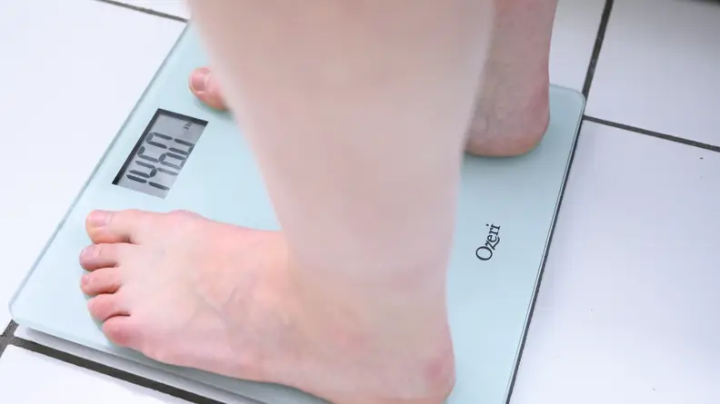 A woman standing on the Ozeri digital scale