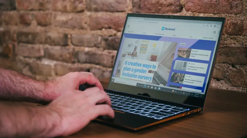 Person types on laptop keyboard