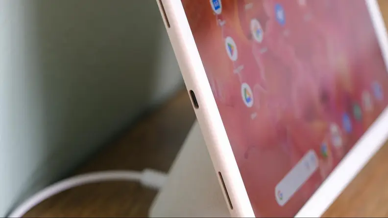 The Pixel Tablet, connected to its dock, in profile. Two of it's four speakers are in view.