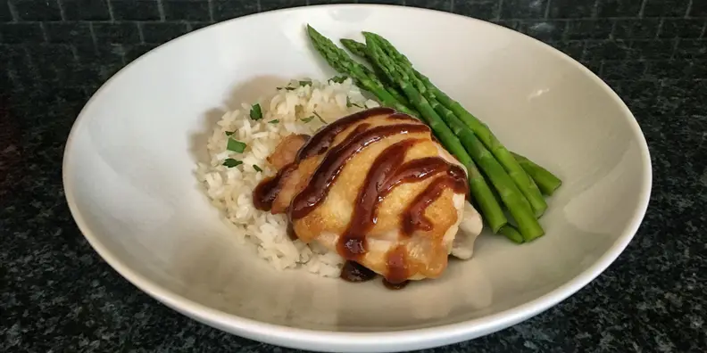 Chicken, rice, and asparagus on a white plate