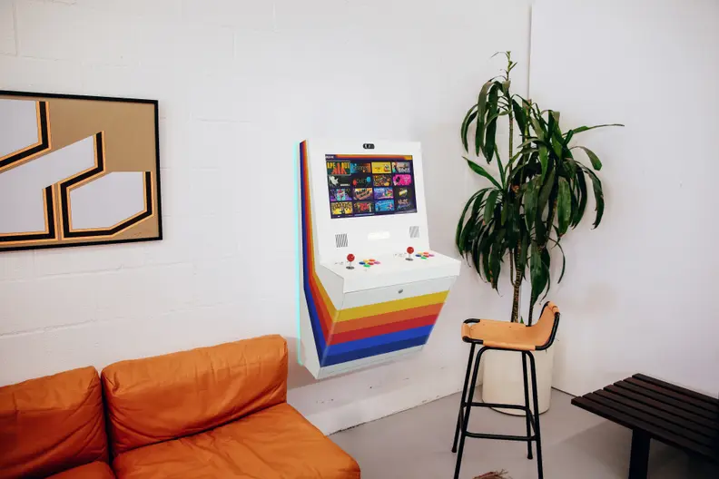 A white polycade sente cabinet hanging on a wall, a home digital arcade cabinet