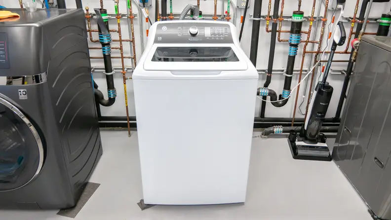 A white GE GTW585BSVWS top-load washing machine with agitator sits in the Reviewed Labs.