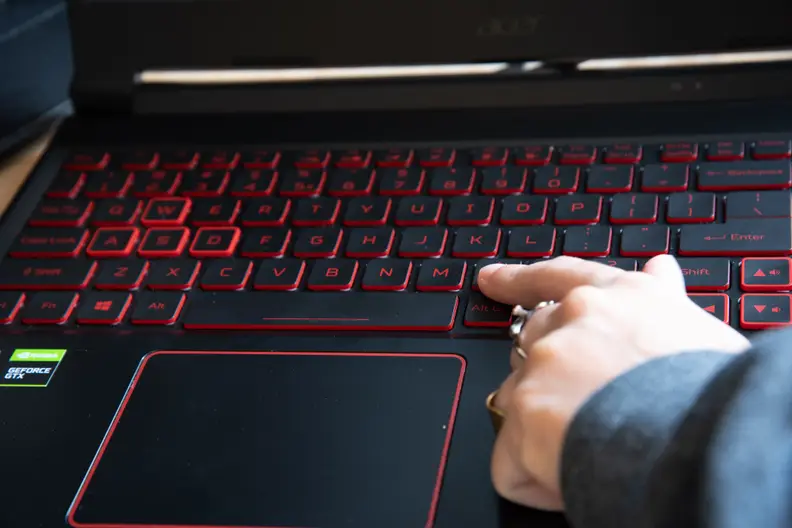 A person points to a key on the keyboard