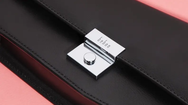 Close-up photograph of the clasp on a black leather Behno handbag.
