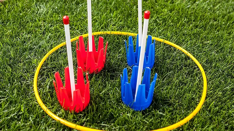 Close up of red and blue lawn darts on grass.