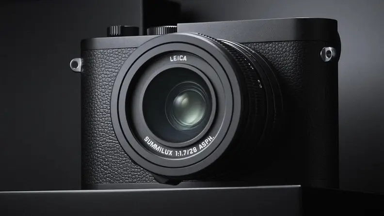 A small black camera against a black and gray background