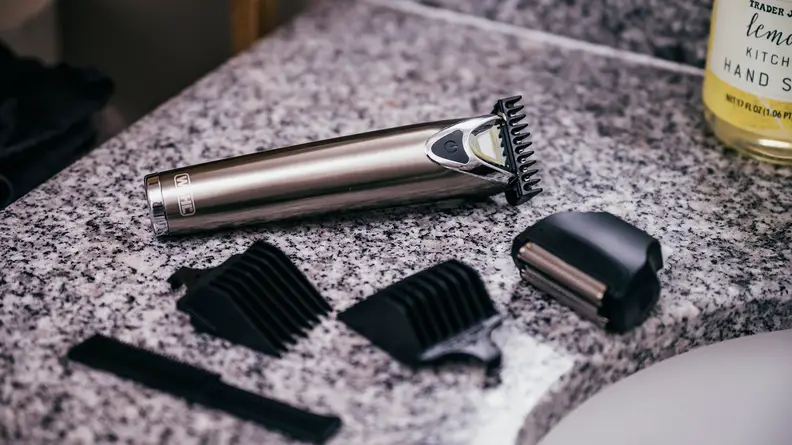 A Wahl beard trimmer and accessories sit on a granite countertop
