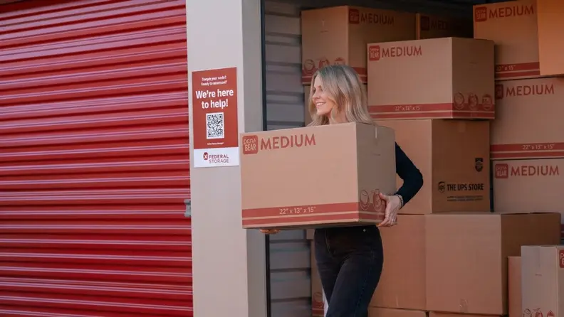 A woman walks out of a red storage unit