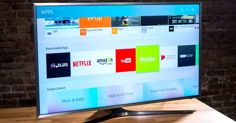 The MU7000 series TV features Y-shaped stands and thin silver bezels. Smooth, lined black plastic covers the rear of the panel.