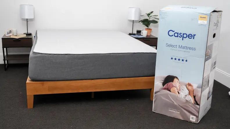 the casper select on a bed frame next to the box