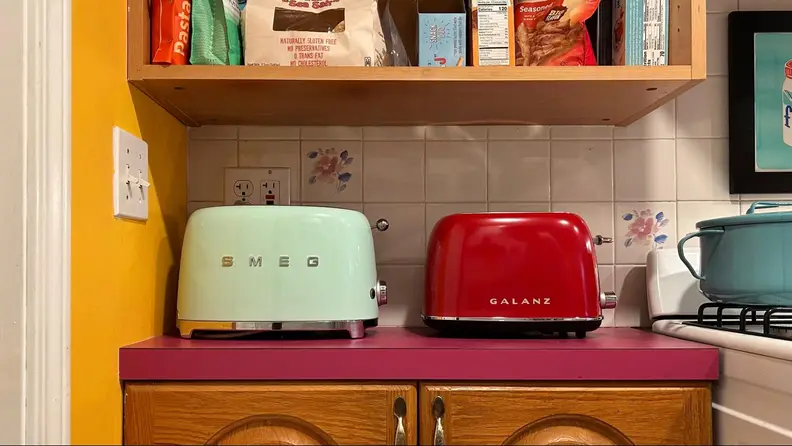 A SMEG mint green toaster and a Galanz red toaster side-by-side.