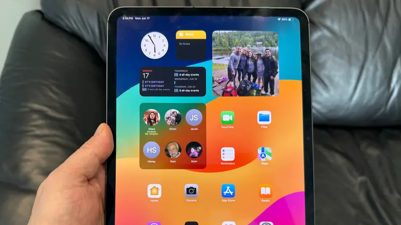An iPad Pro being held by it's user in a portrait orientation.