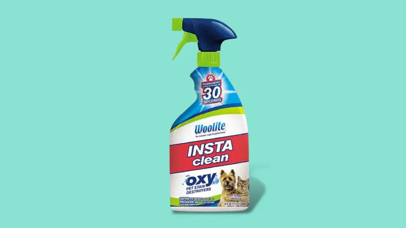A bottle of Woolite spray against a teal background.