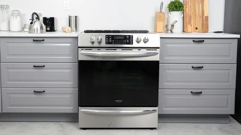 The Frigidaire FGEH3047VF electric range installed between two grey kitchen cabinets.