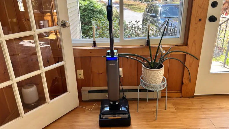 A floor mop stands in its dock by a door and windro
