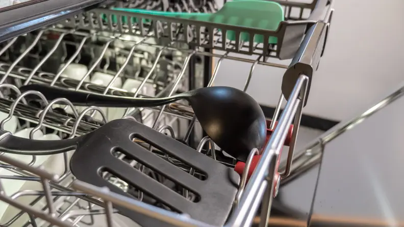 A close-up of the KitchenAid KDPM804KBS dishwasher's third rack, with some larger kitchen utensils added for scale.