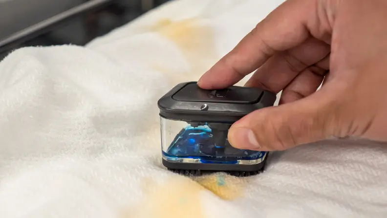 The WTW8127LC's pretreat brush cleaning a tea stain on a blanket.