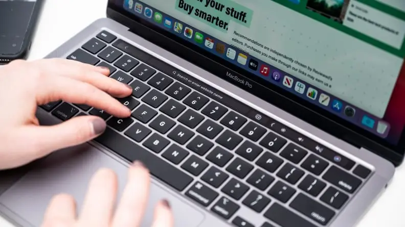 Person hovers finger over keyboard on laptop