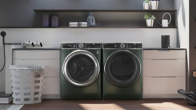 The jade green GE Profile PFW955SPWGN with matching dryer in a laundry room.