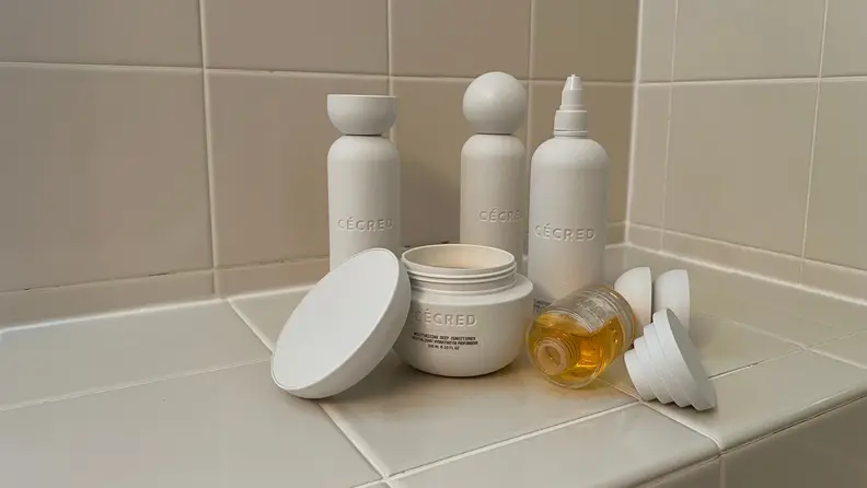 Many Cecred haircare products on a beige countertop.