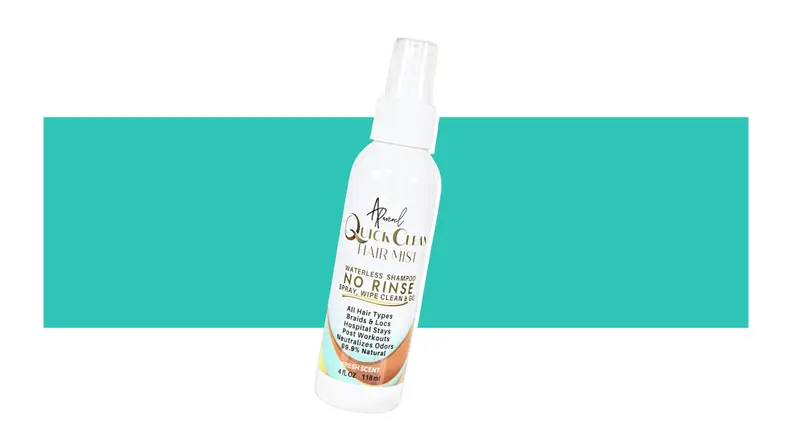 A spray bottle of  Quick Clean Hair Mist All-Natural in front of a background.