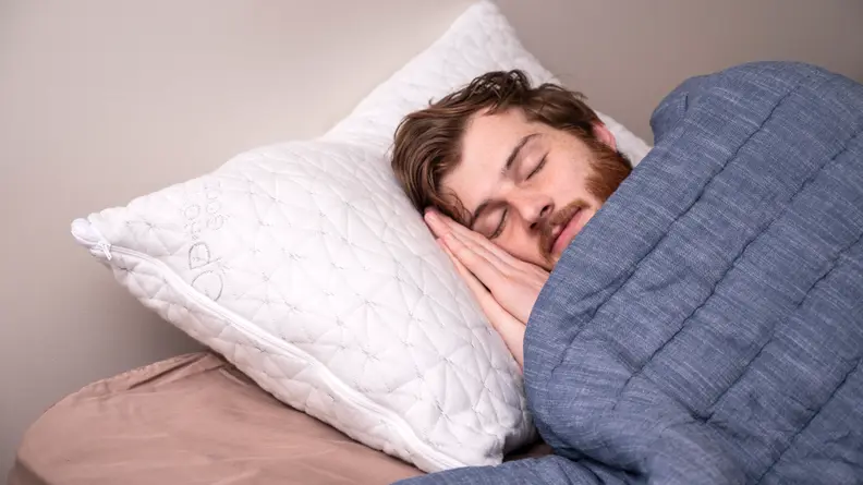 a man sleeps on the Coop Home Goods Original Pillow