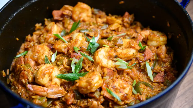 A pan of jambalaya, with rice, shrimp, and fresh herbs.
