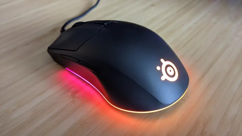A computer mouse with glowing lights coming from the bottom, the steelseries rival 3, one of the best gaming mice you can buy right now