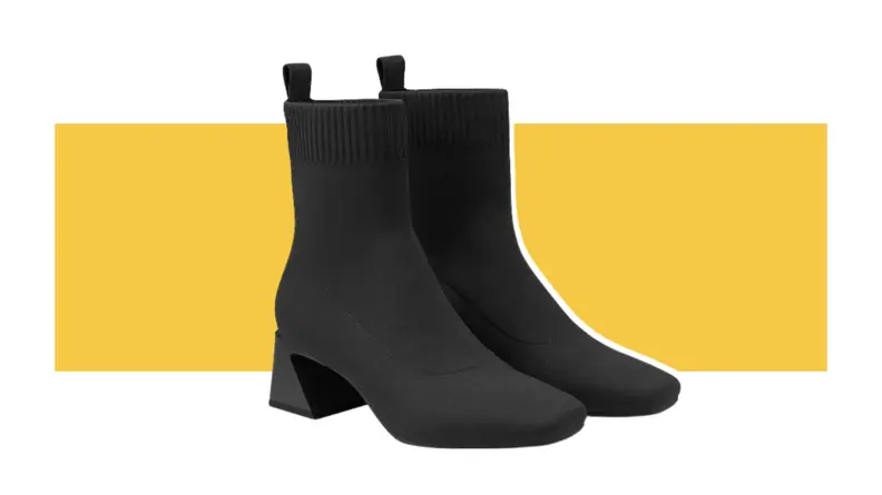 Two black Regina Pro boots against a yellow background