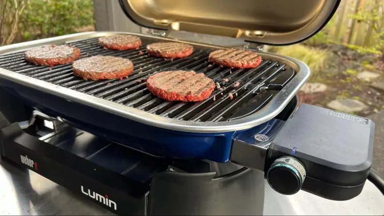 Burger patties being grilled on the Weber Lumin.