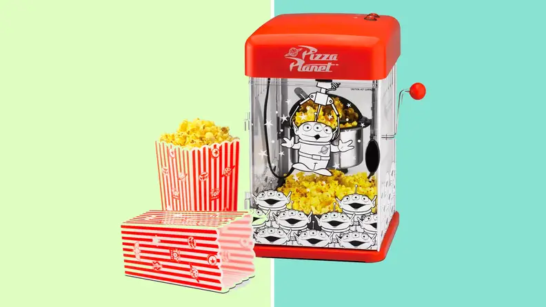 A red popcorn maker on a green background