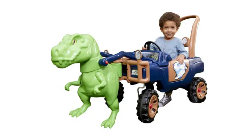 A child rides a dinosaur peddle car