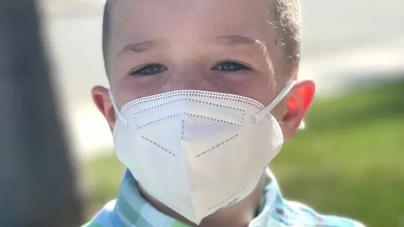 A boy wears a mask