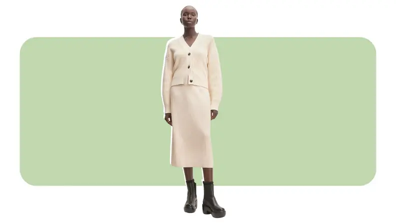 A model wearing a cream sweater-skirt.