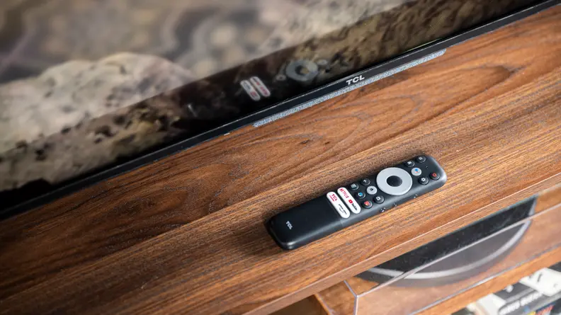The TCL 5-Series with Google TV sitting on a tabletop next to its remote control