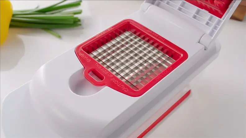 Red veggie chopper on cutting board