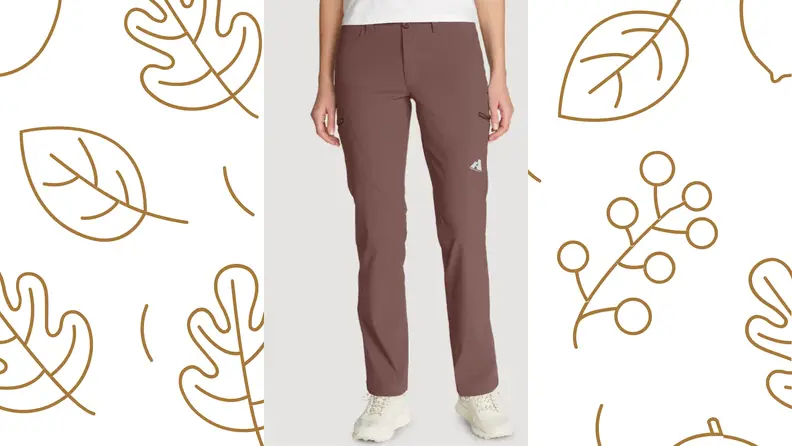 A person stands in a pair of pants from the waist down, over a leaf-printed background