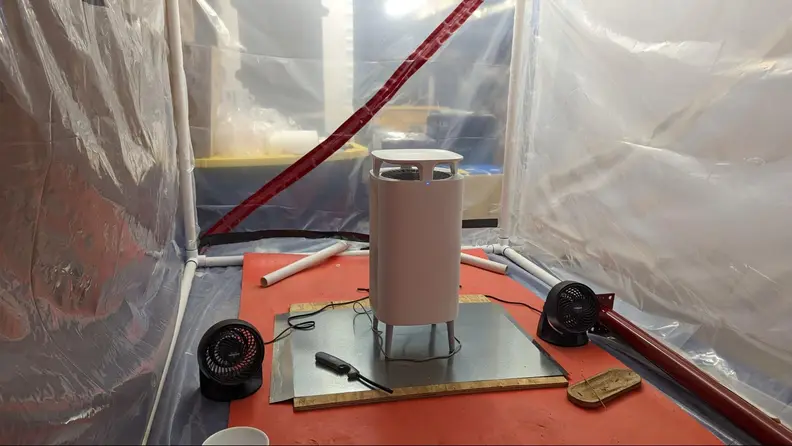 A white standing air purifier in a controlled laboratory setting.