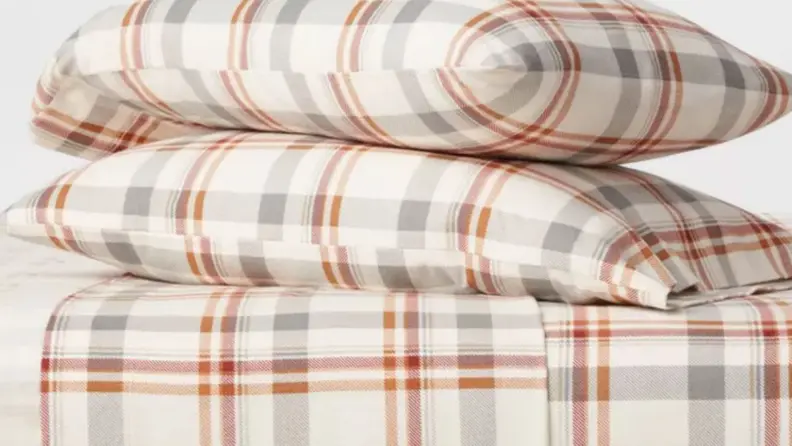 a stack of two pillows atop a mattress made in plaid flannel sheets