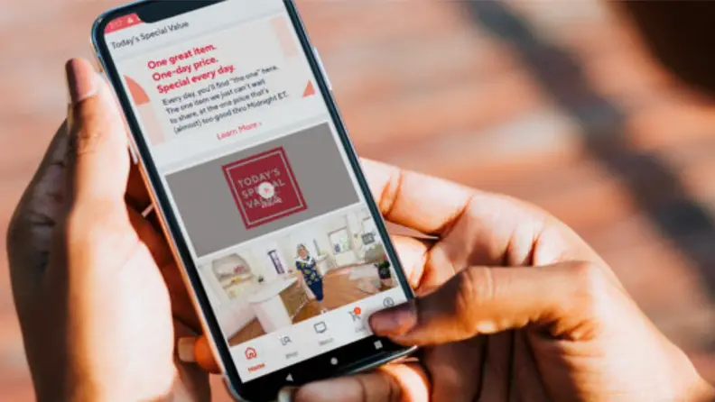 An image of a person holding a phone with the QVC newsletter opened.