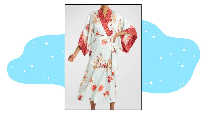 A model wearing a robe printed with dragon symbols.